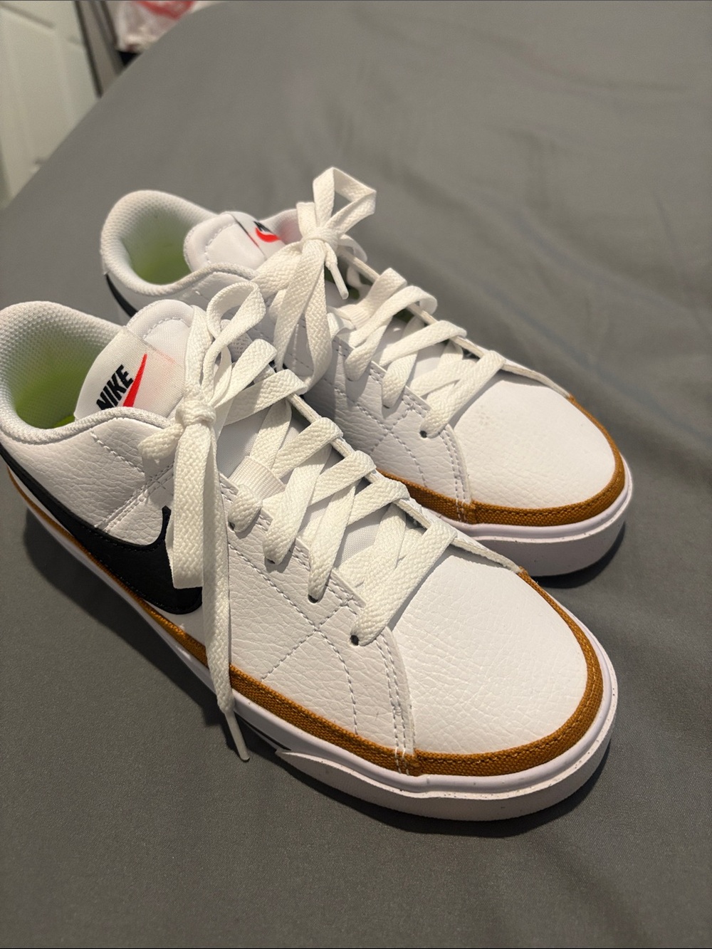 Nike White Low-Top Sneakers with Black Swoosh and Brown Accent
